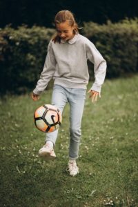 Une jeune fille qui joue au ballon de foot