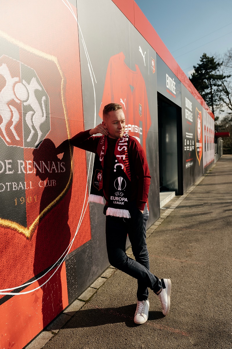 un supporter du stade rennais devant un mur avec l'écharpe lors de sa séance photo à Rennes