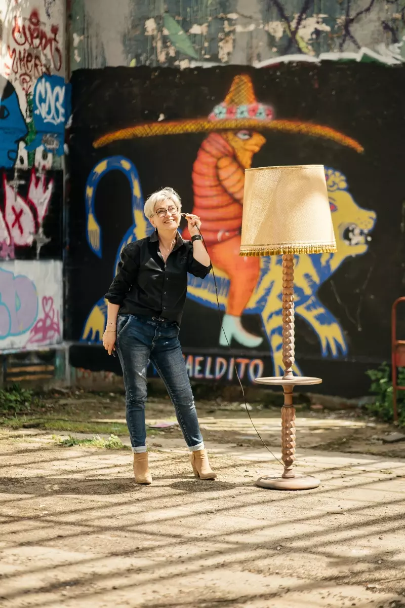 Femme tenant un téléphone à fil à l'oreille dans une zone urbex abandonnée. Mélange de modernité et nostalgie, connexion passé-présent. Atmosphère intrigante et mystérieuse lors d'un shooting photo à Rennes